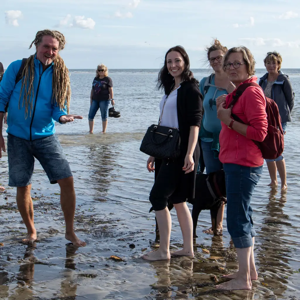 Gruppe bei einer geführten Bernsteinsuche im flachen Wasser der Nordsee in St. Peter-Ording